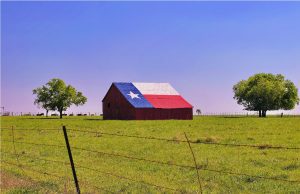 A barn on a Texas ranch with the state flag painted on the roof