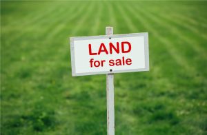 land for sale sign against trimmed lawn background
