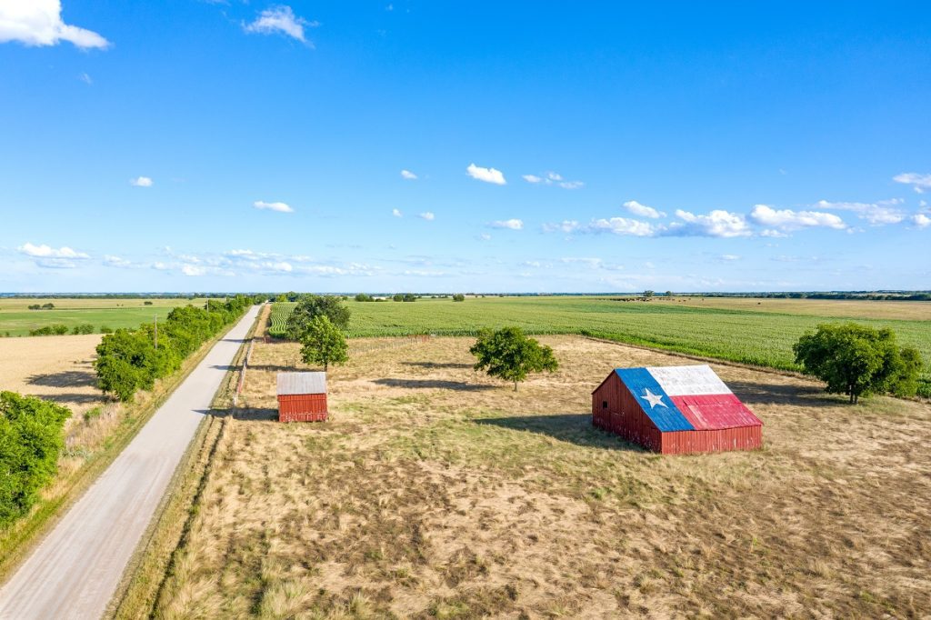 A barn with a Texas flag painted on the roof