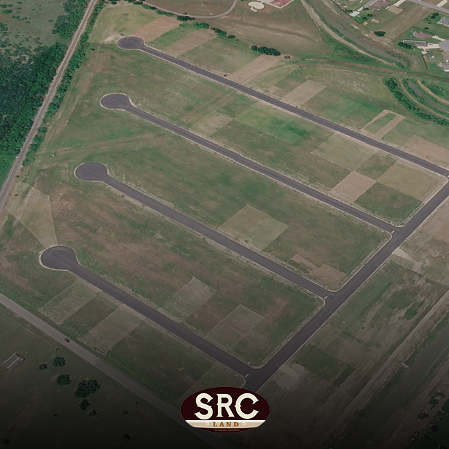 Aerial view of a new residential development with three long curved cul-de-sacs and surrounding rectangular lots.